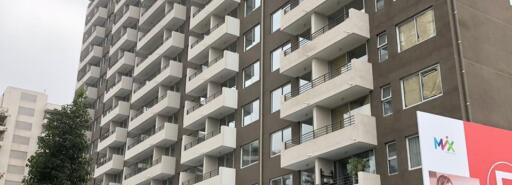 Brown and white apartment building with green grass in the foreground