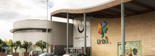 Urbil façade with cars parked near entrance