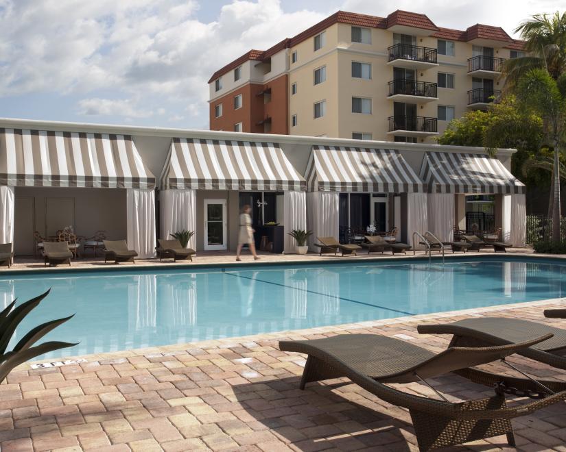 Beach Place pool with chaise longue in foreground and cabanas in background