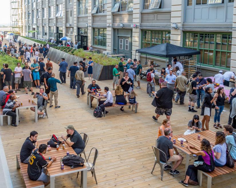 Groups of people socializing in an outdoor common area between two building.