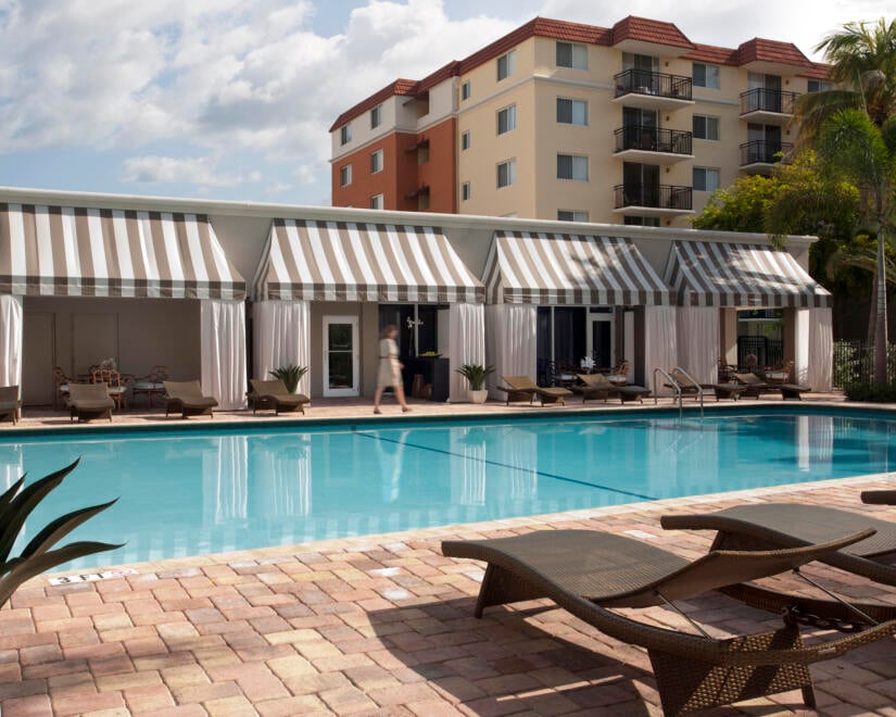 Beach Place pool with chaise longue in foreground and cabanas in background