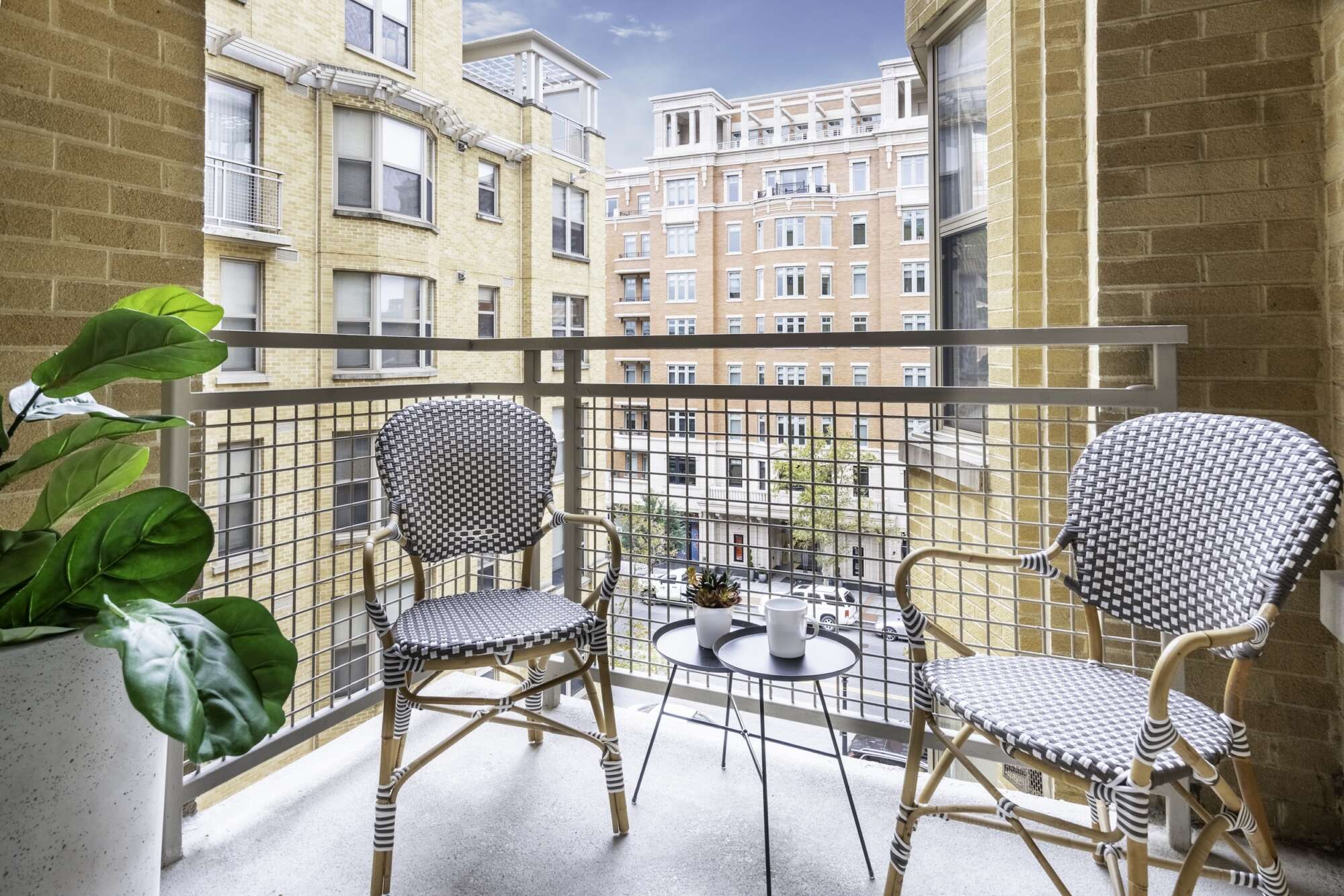 Patio of a model apartment at The Ellington with two chair and a blue sky in the distance