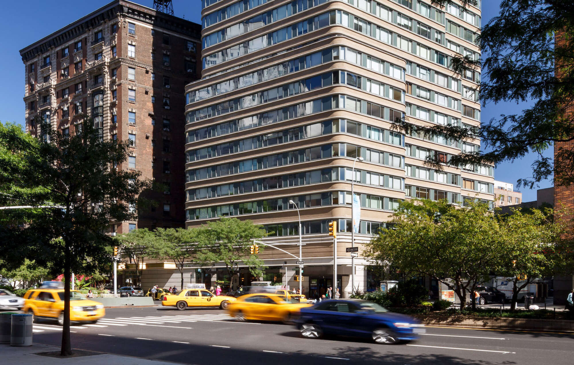 2000 Broadway building exterior with cars on tree lined street