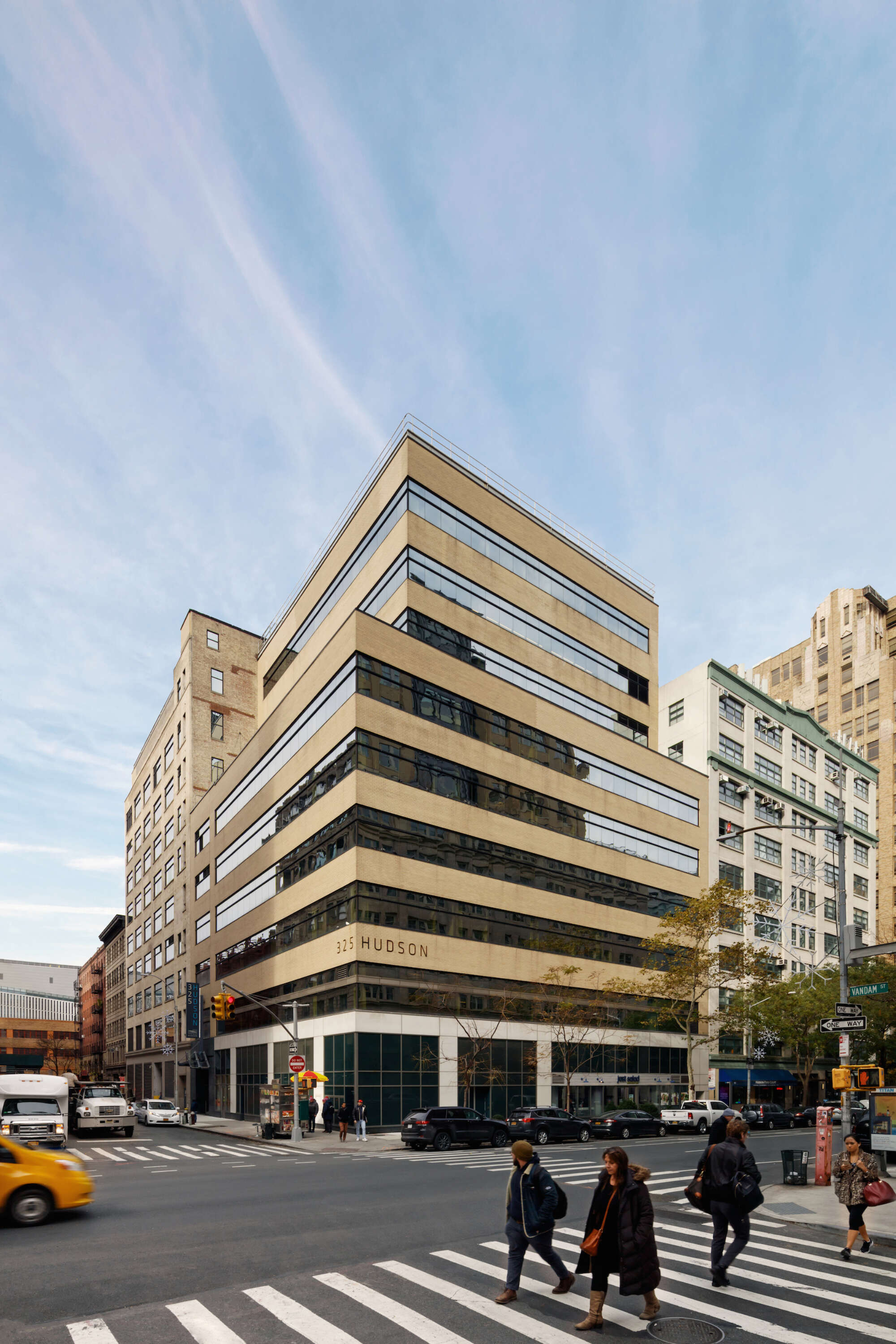325 Hudson building facade at corner of intersection with pedestrians in crosswalk