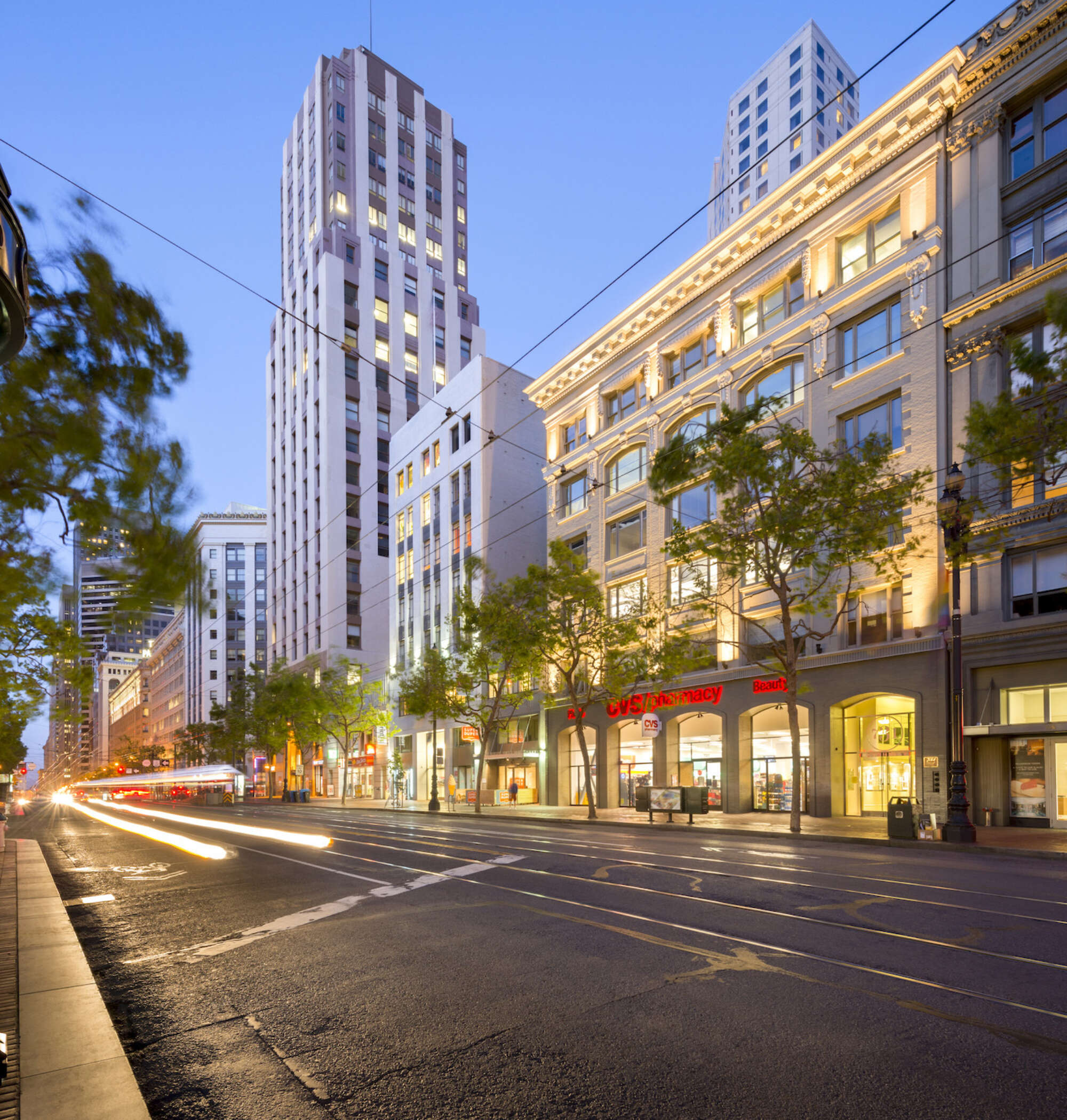 731 Market facade at dusk with motion blurred car headlights streaking down street and high rises in background
