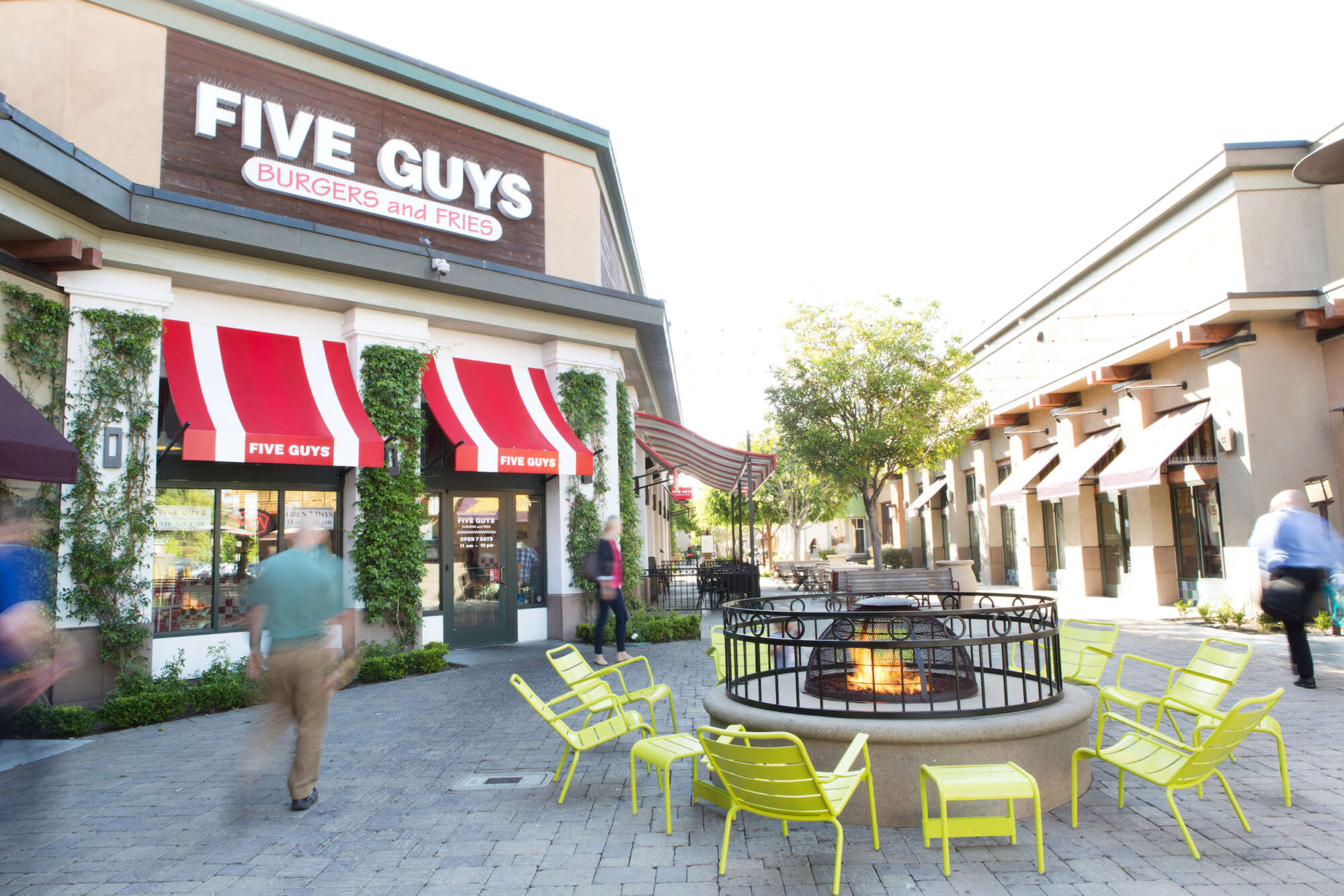 Alameda South Shore Center common area with fire pit and rows of restaurants and shops