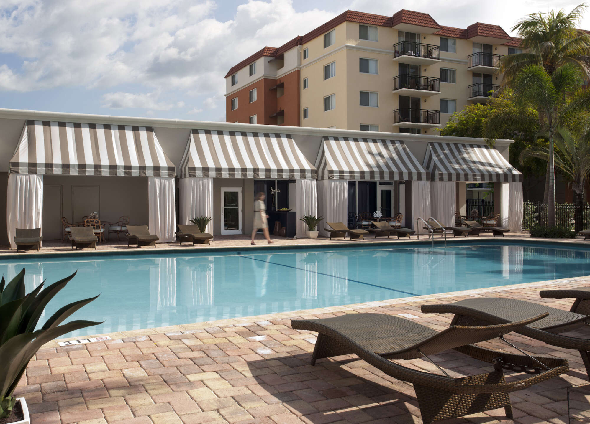 Beach Place pool with chaise longue in foreground and cabanas in background