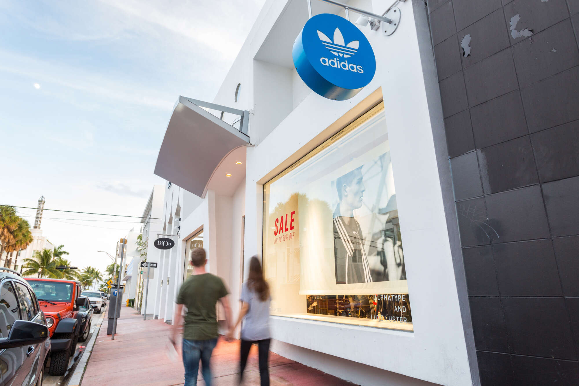 People walking by Adidas at Collins Avenue Collection