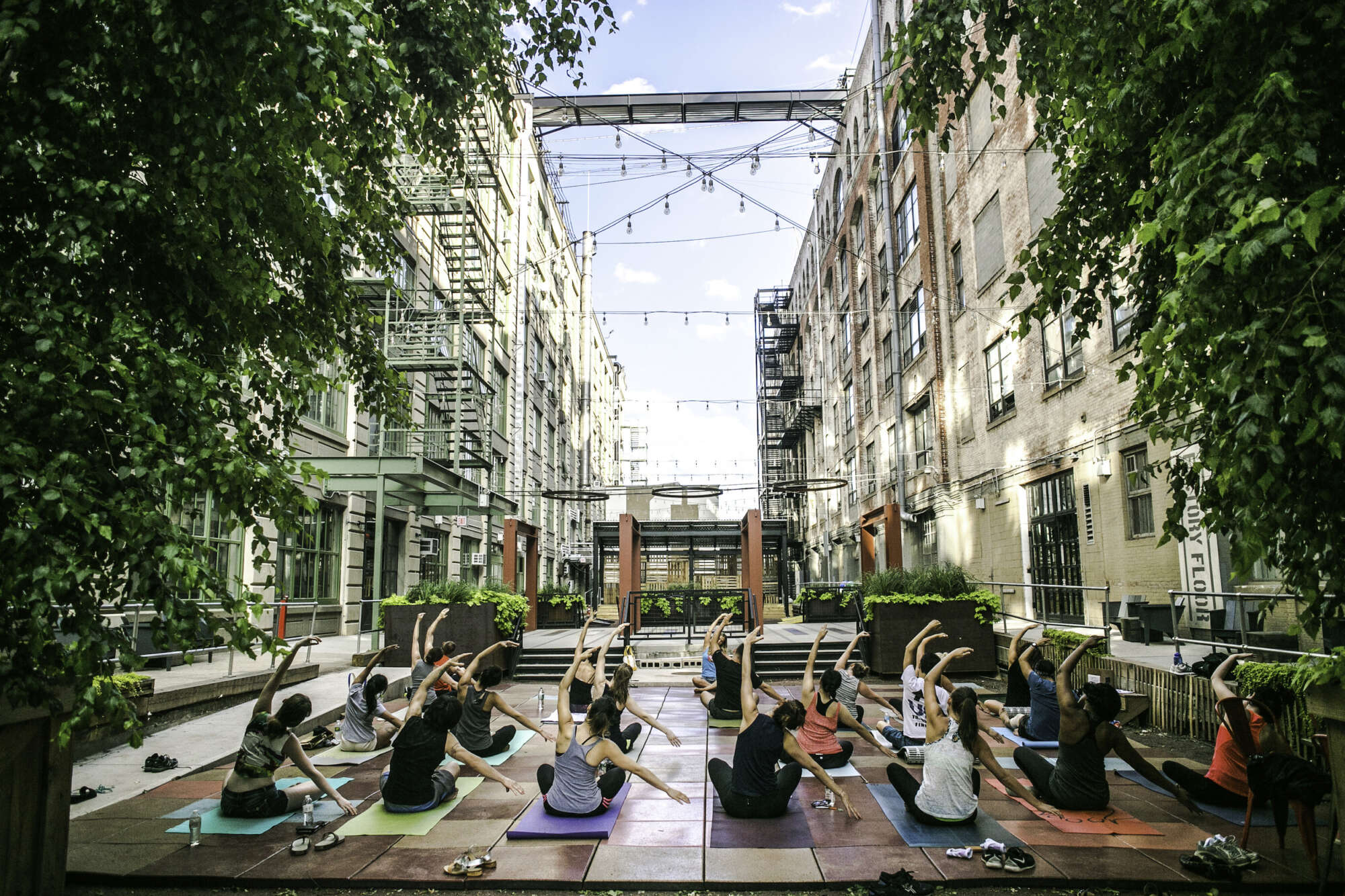 Industry City courtyard with guests practicing yoga at a class