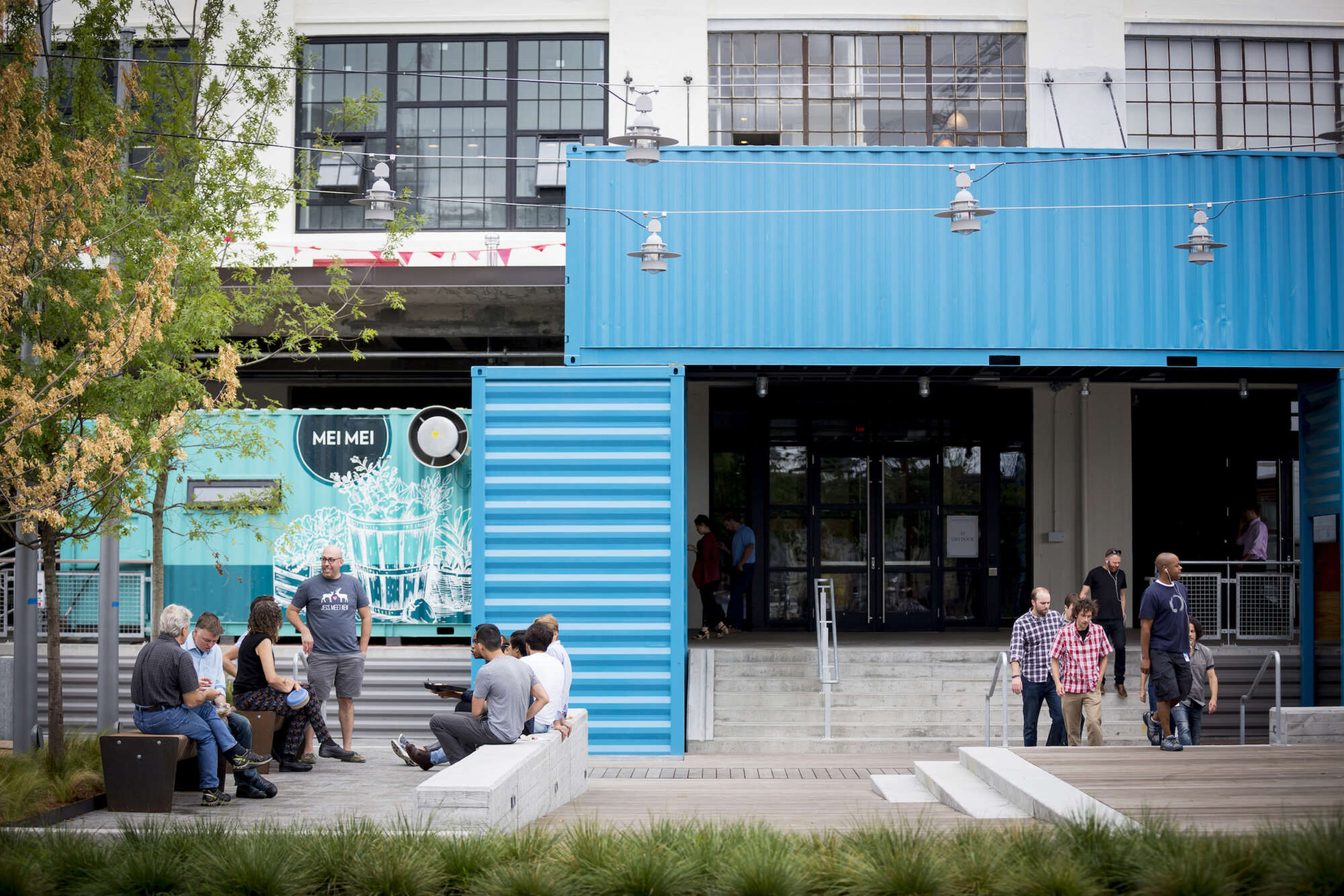 People outside in the common area at street level of The Innovation and Design Building