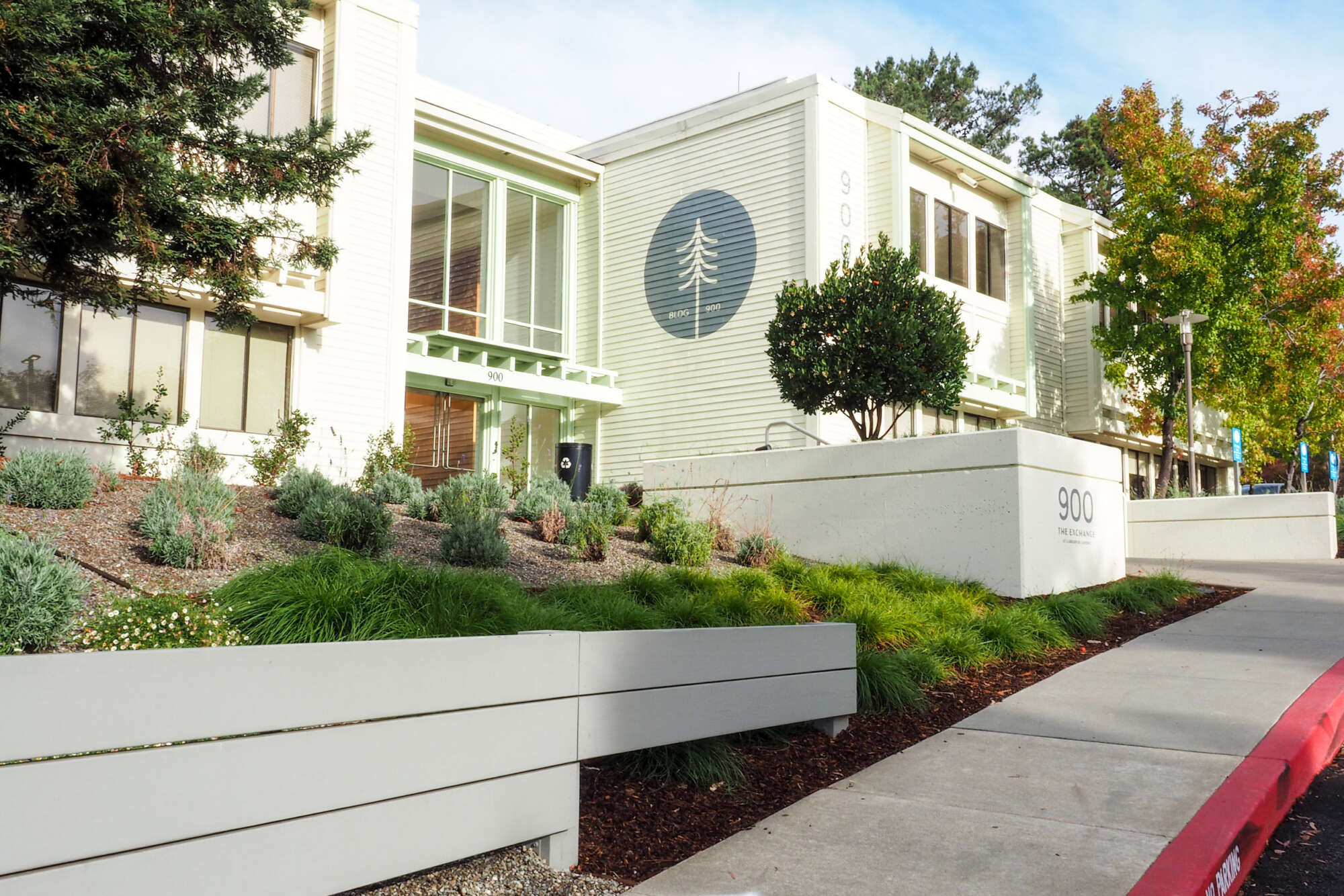 Exterior of The Exchange at Larkspur Landing with large trees under a clear sky
