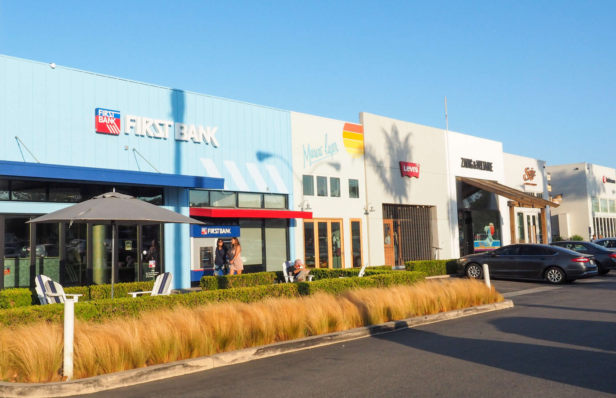 Exterior of Malibu Village with parking lot in the foreground