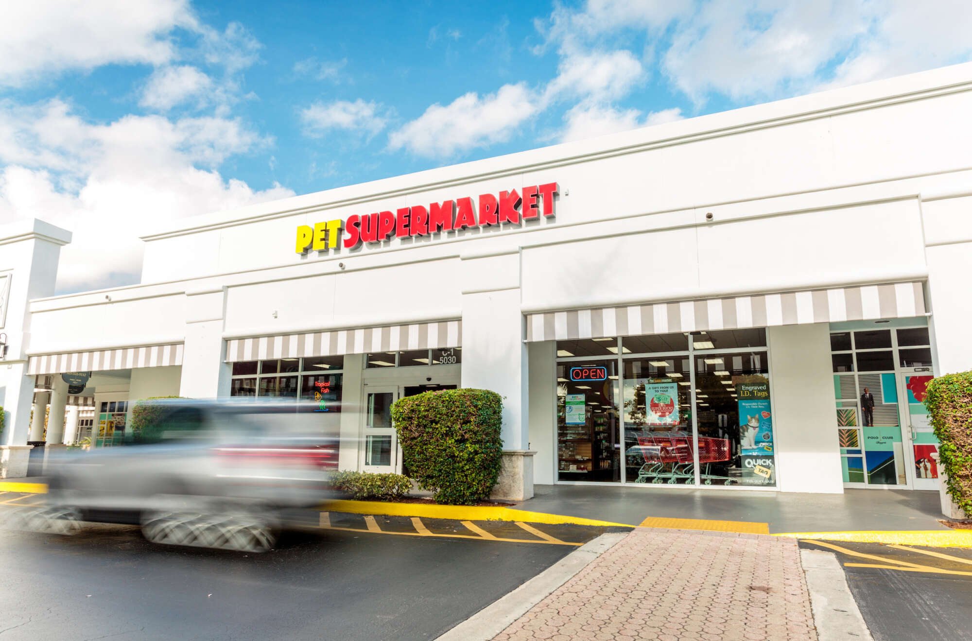 Car moving past a Pet Supermarket in Polo Club Shops
