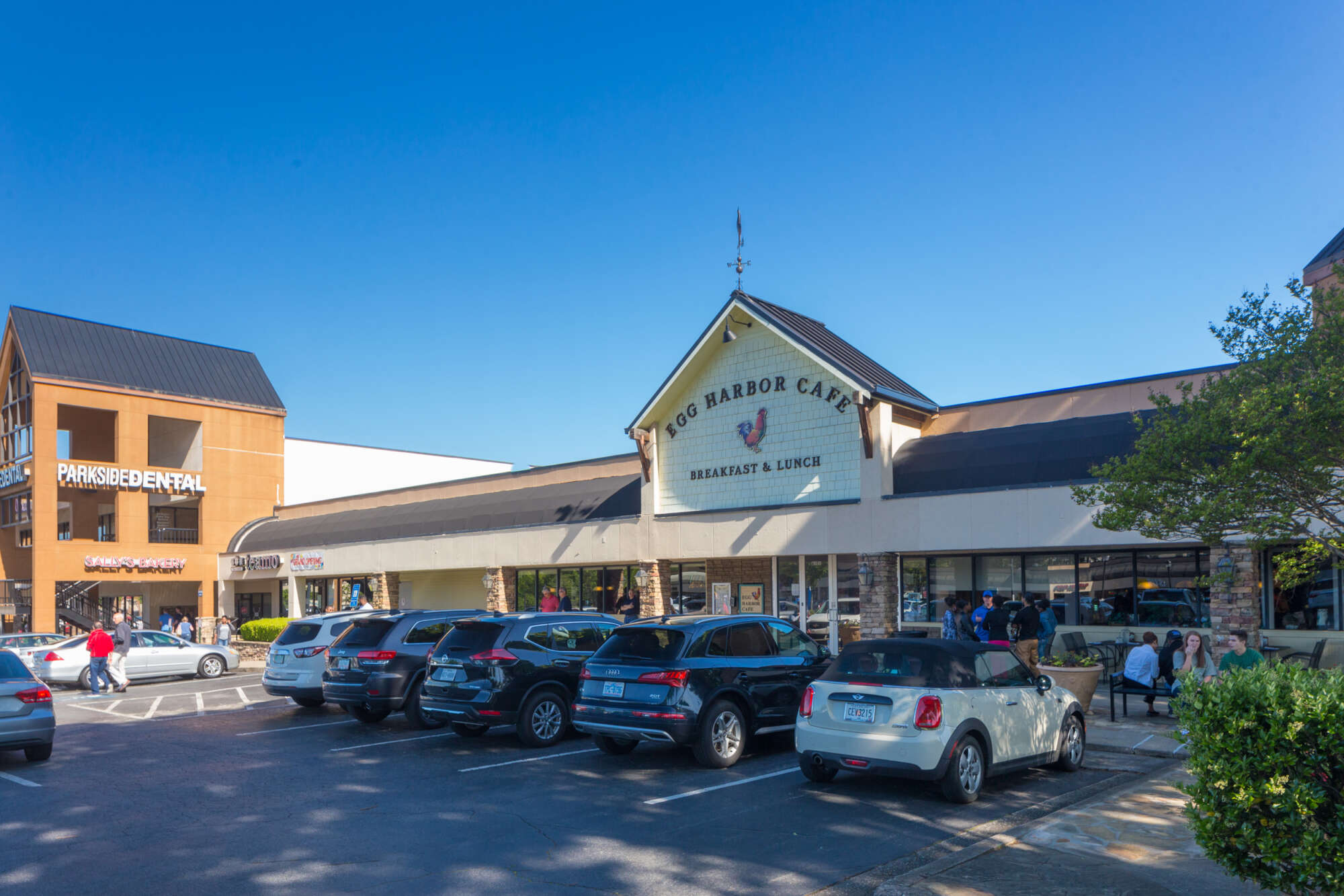 The Egg Harbor Cafe restaurant at Parkside Shops with people and cars in the foreground