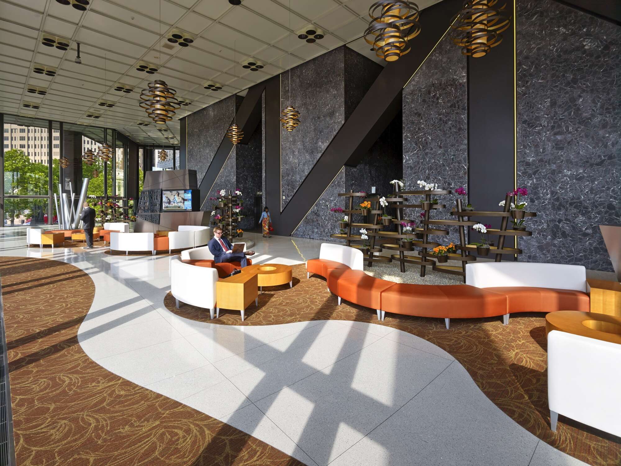 Lobby of U.S. Steel Tower with large windows, tall ceilings and curved colorful seating